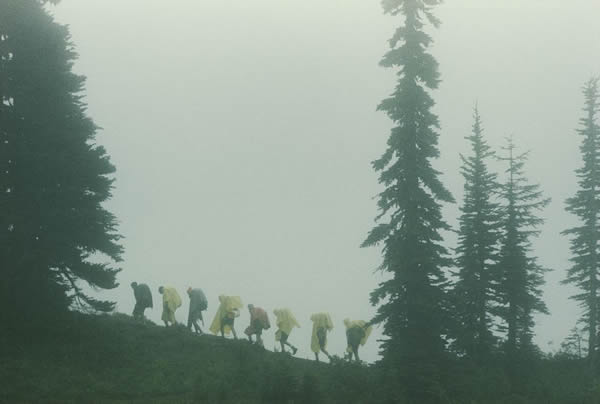 雷尼尔峰的天气反覆无常，走在公园步道的女童子军穿上了雨衣。