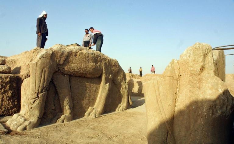 2001年7月，伊拉克工人在尼姆鲁德考古遗址清理一座有翅膀的牛雕像。 Photograph by Karim Sahib, AFP, Getty Images
